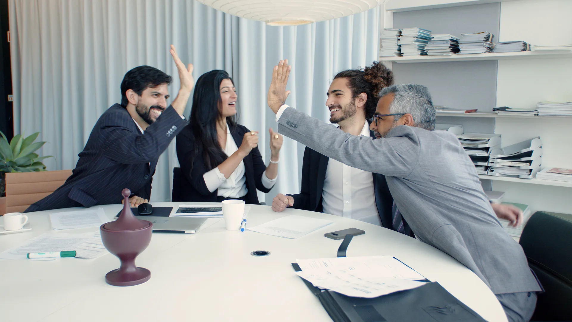 The team high-fiving around the table after a win